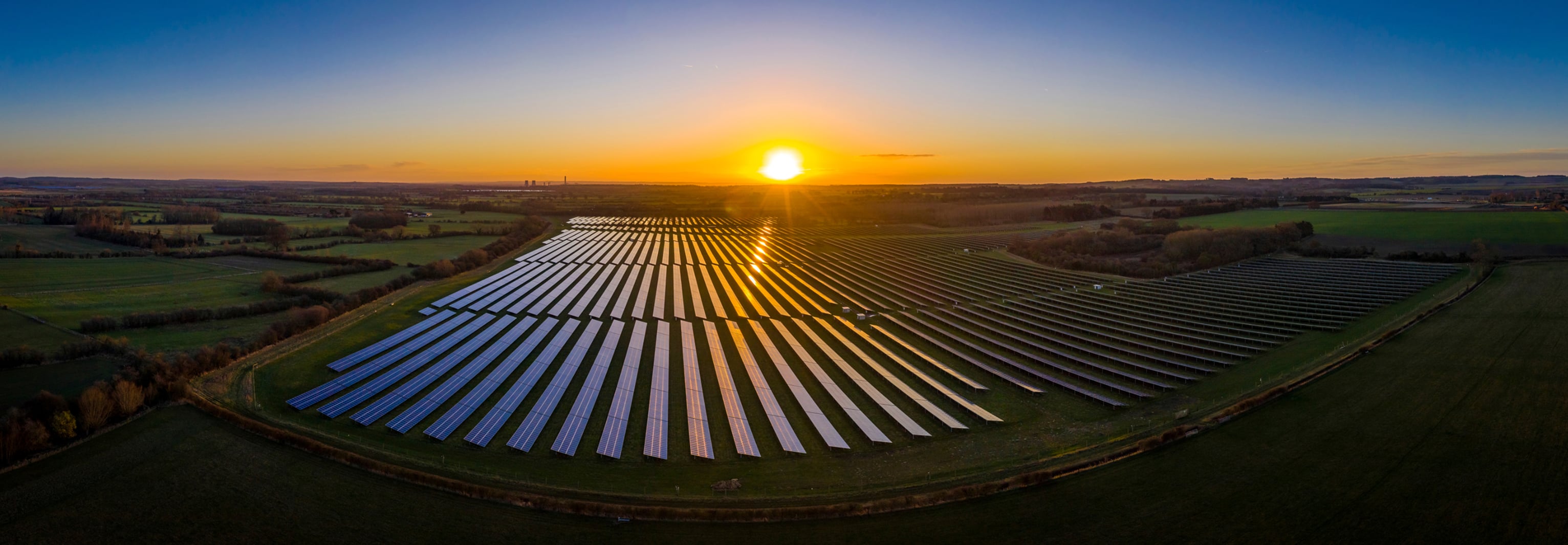 Excelsior - A panoramic view of a large solar farm at sunset